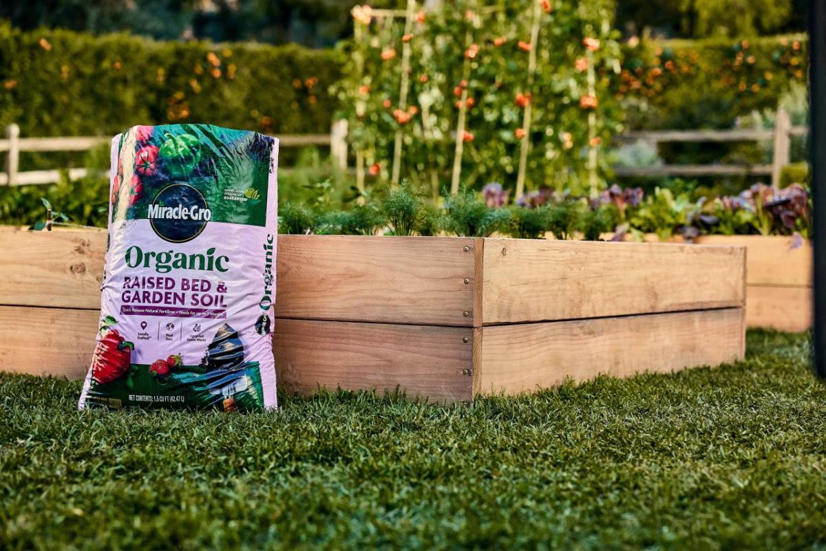 Bag of Miracle-Gro Raised Bed & Garden Soil leaning against a raised bed