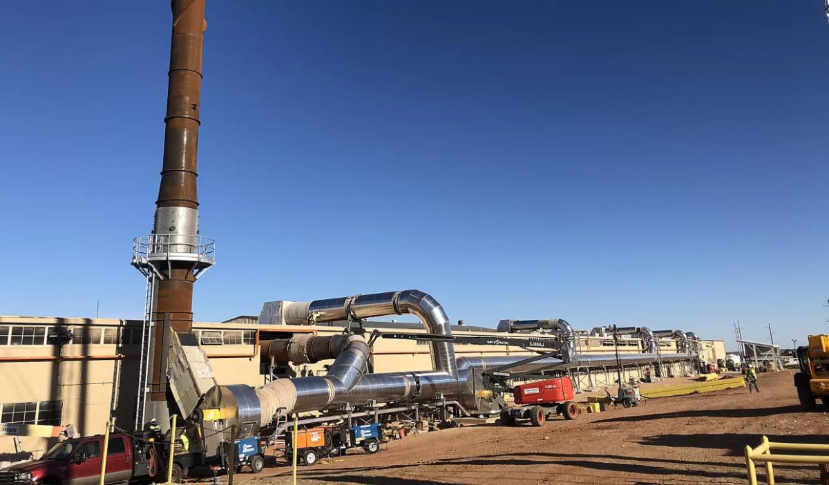 A large industrial plant, a clear blue sky behind.