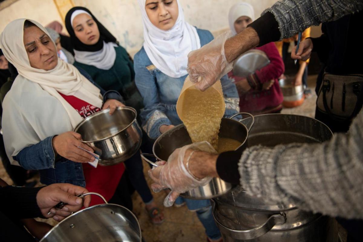 In Aleppo, women living in a shelter—rehabilitated by Action Against Hunger—queue for their daily meals.