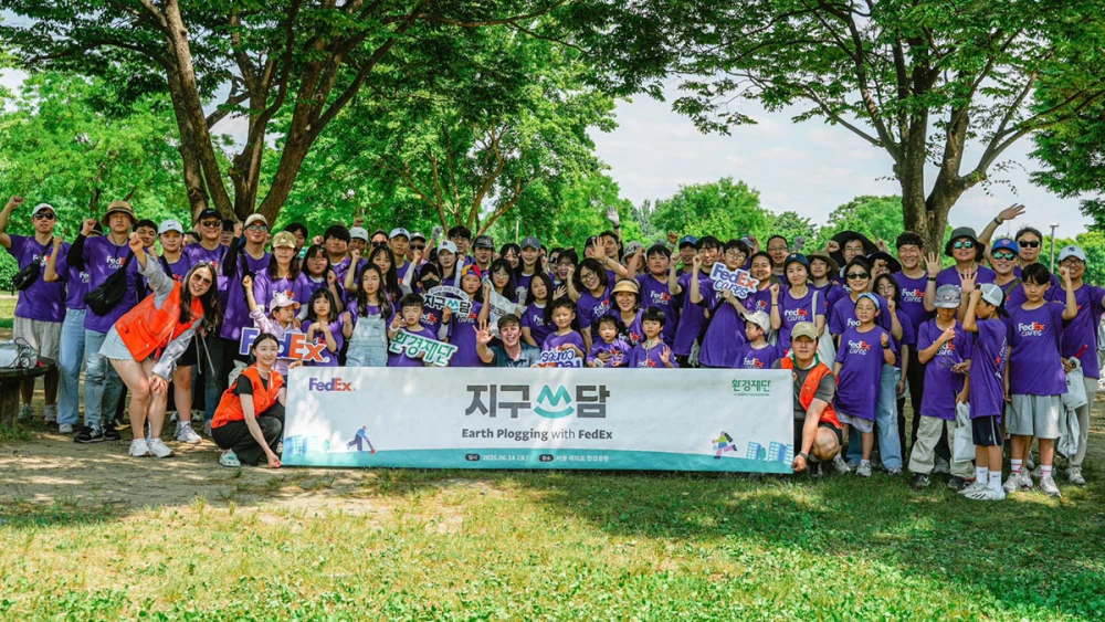 A large group posing together with a sign reading "Earth Plogging with FedEx'
