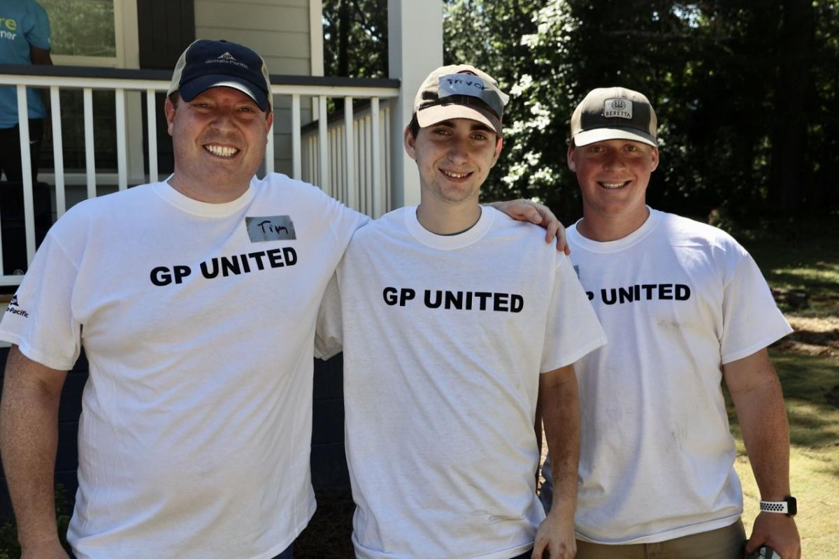 team standing in front of house