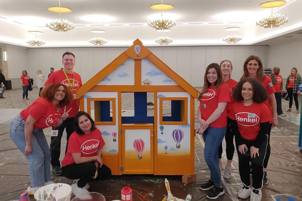 A group surrounding a finished playhouse.