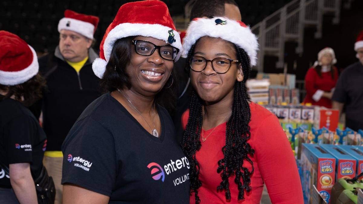 Two volunteers in santa hats posed together.