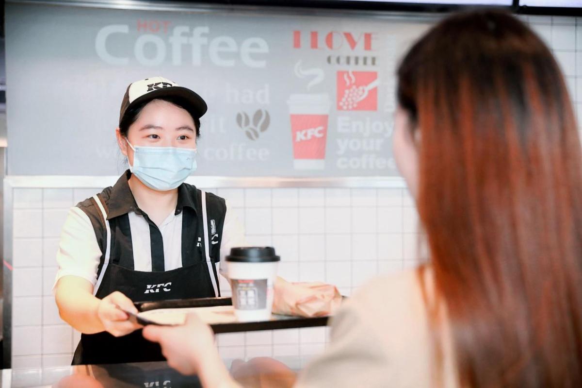 KFC employee with drink on a tray