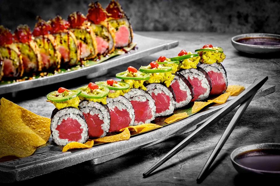 Two trays of precisely arranged sushi rolls.