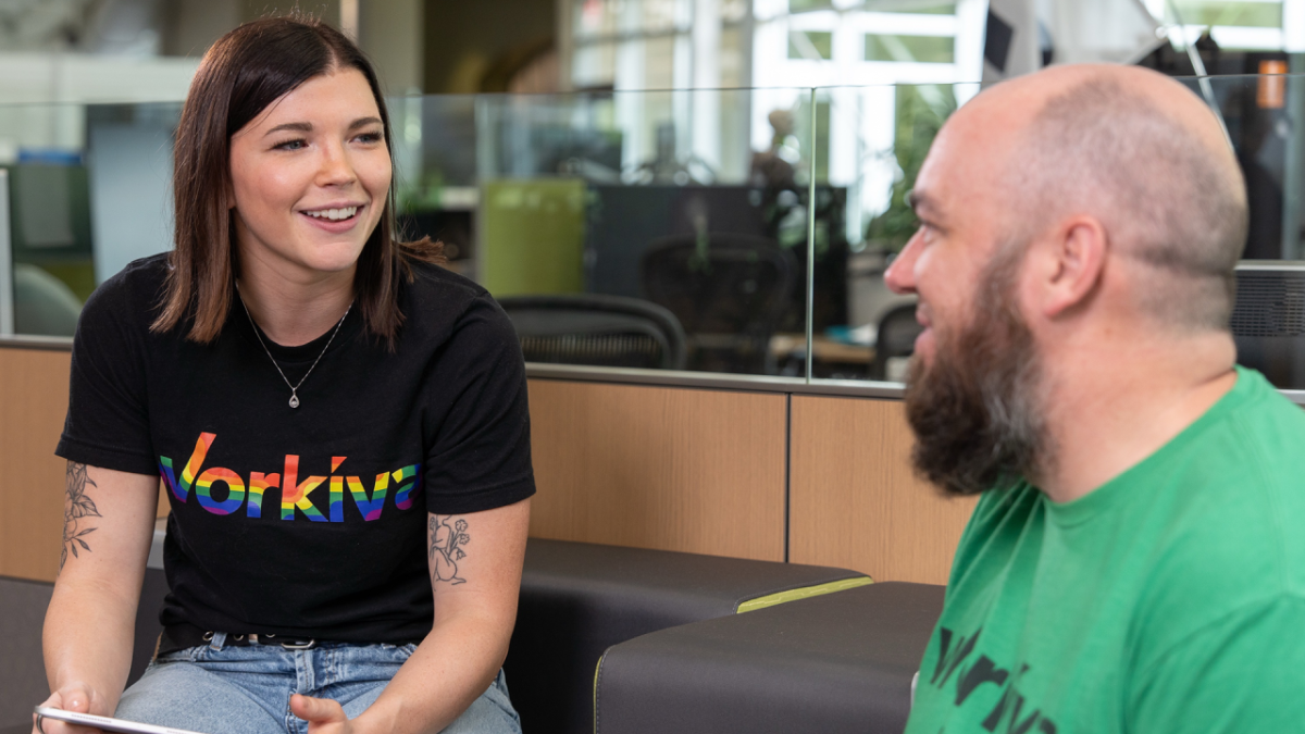 Two people smiling and talking in an office