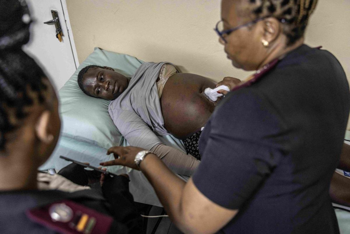 Healthcare professional using an ultrasound on a patient.