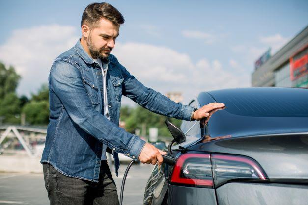 a man charging his electric vehicle