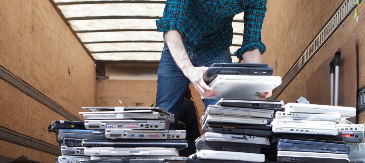 man loading a trailer with recycled laptops