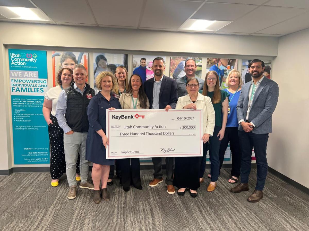 People standing together holding a large check