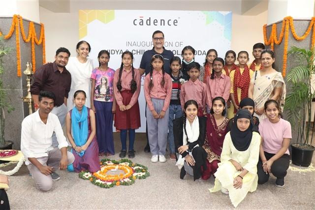 A group of children and adults in front of a sign for Cadence.