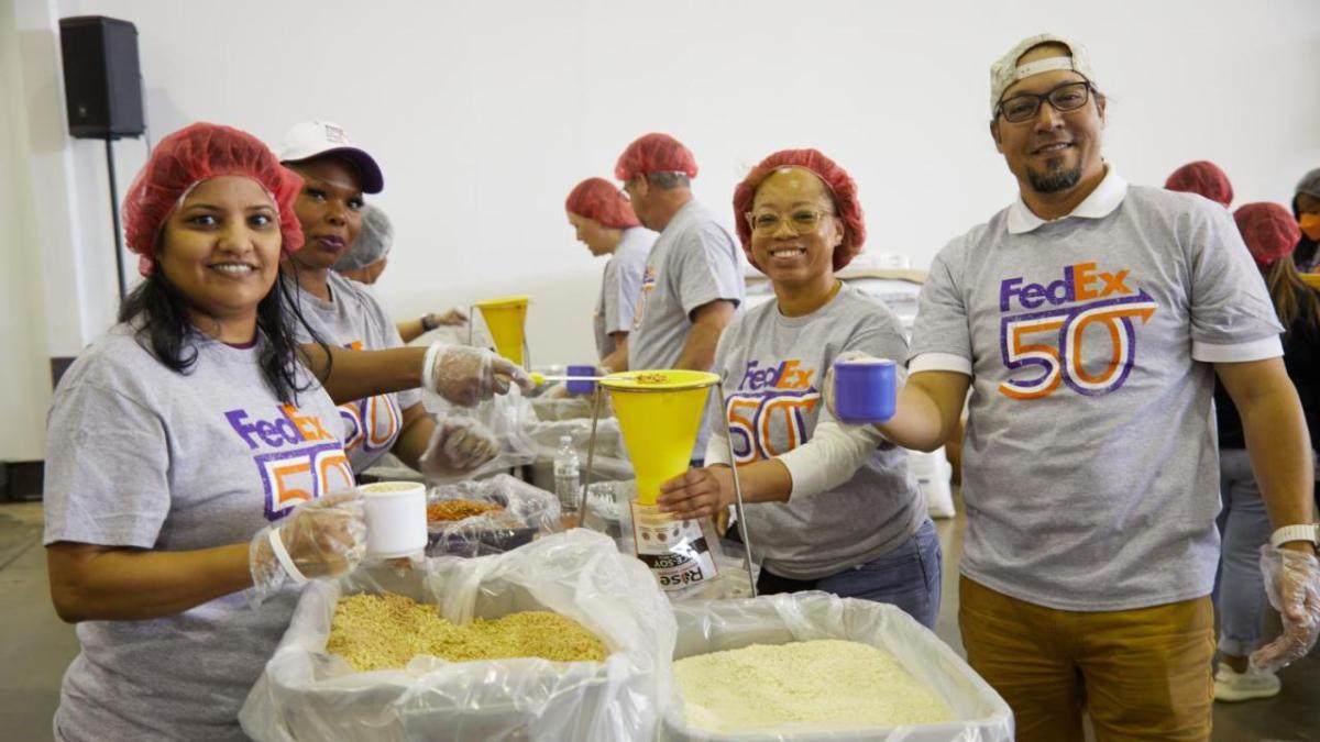 Volunteers scooping food from boxes.