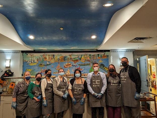 A group of volunteers posed wearing matching aprons.