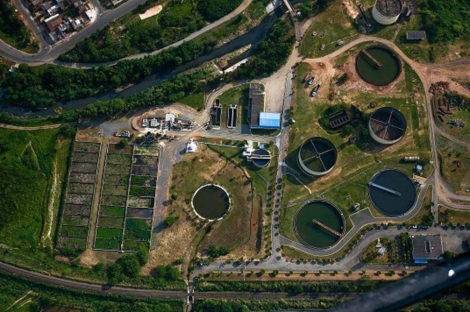 aerial view of a water treatment facility, many large pools of water and buildings.