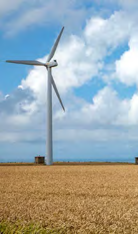 Windmill in an open field, partially cloudy sky