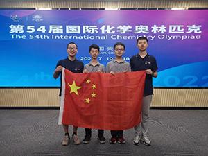 Four people stand holding a Chinese flag