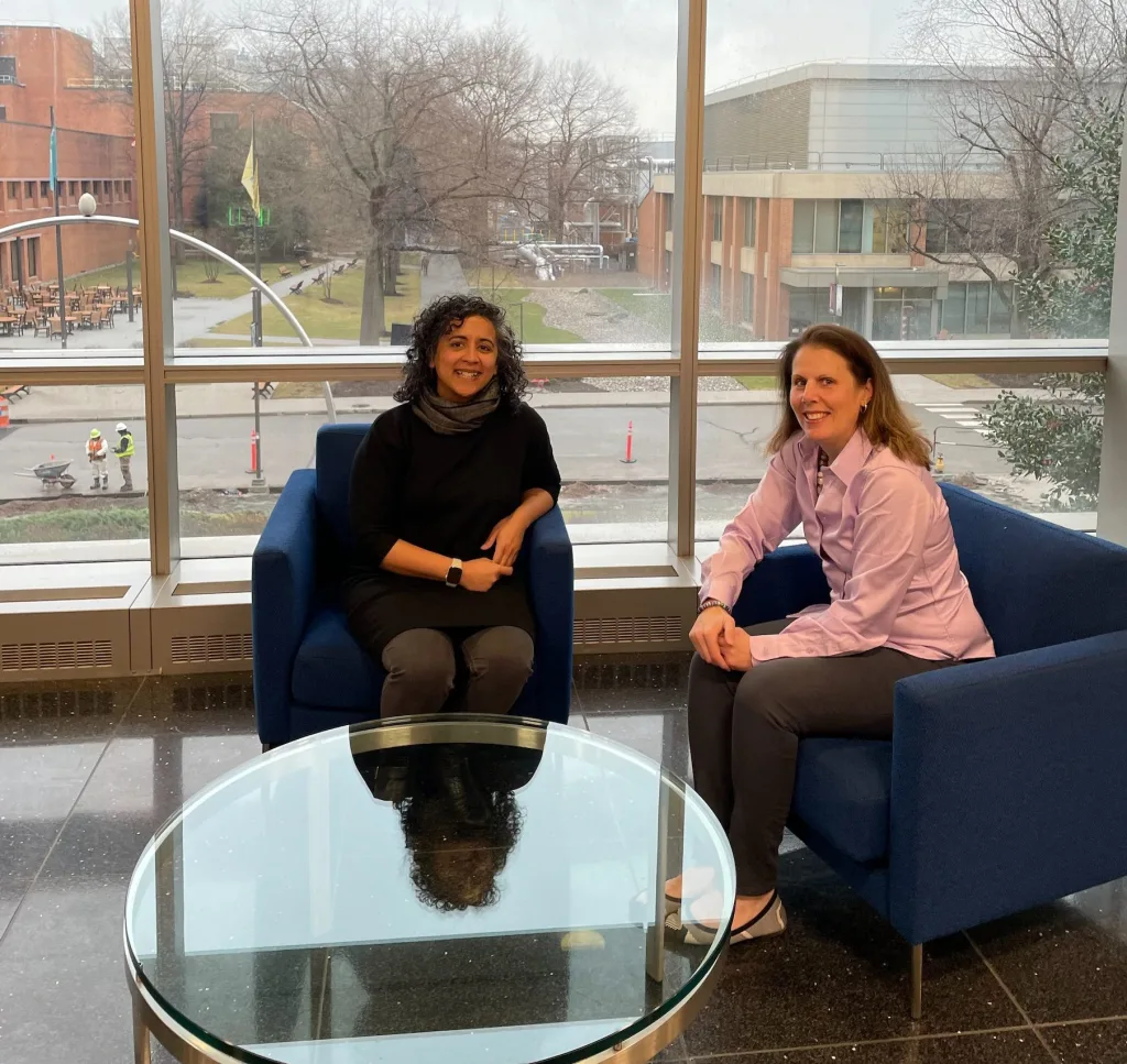 two women sitting together in an office building