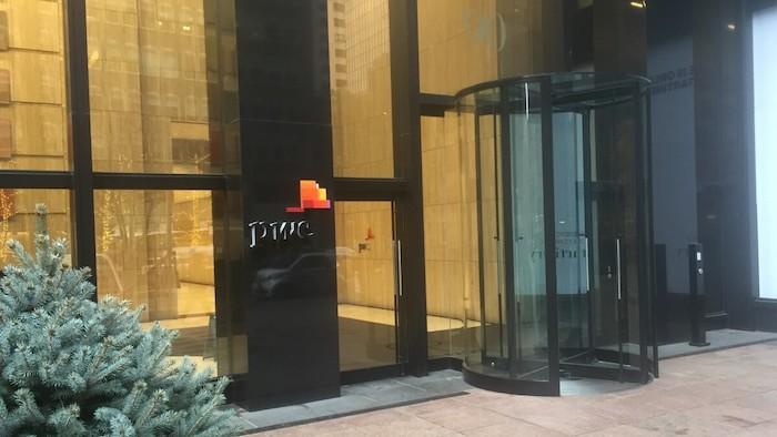 Outside shot of PwC offices. Showing PwC logo on building and revolving door.