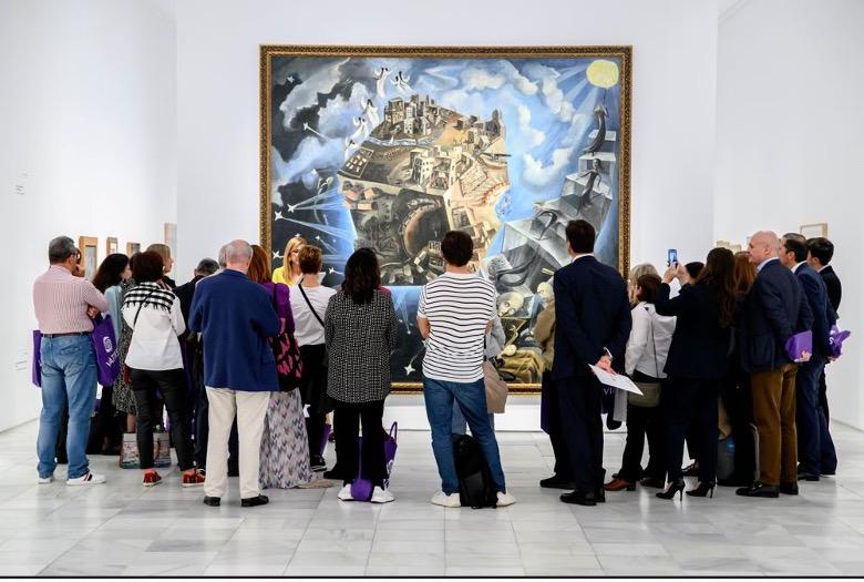 A small crowd admiring a large painting