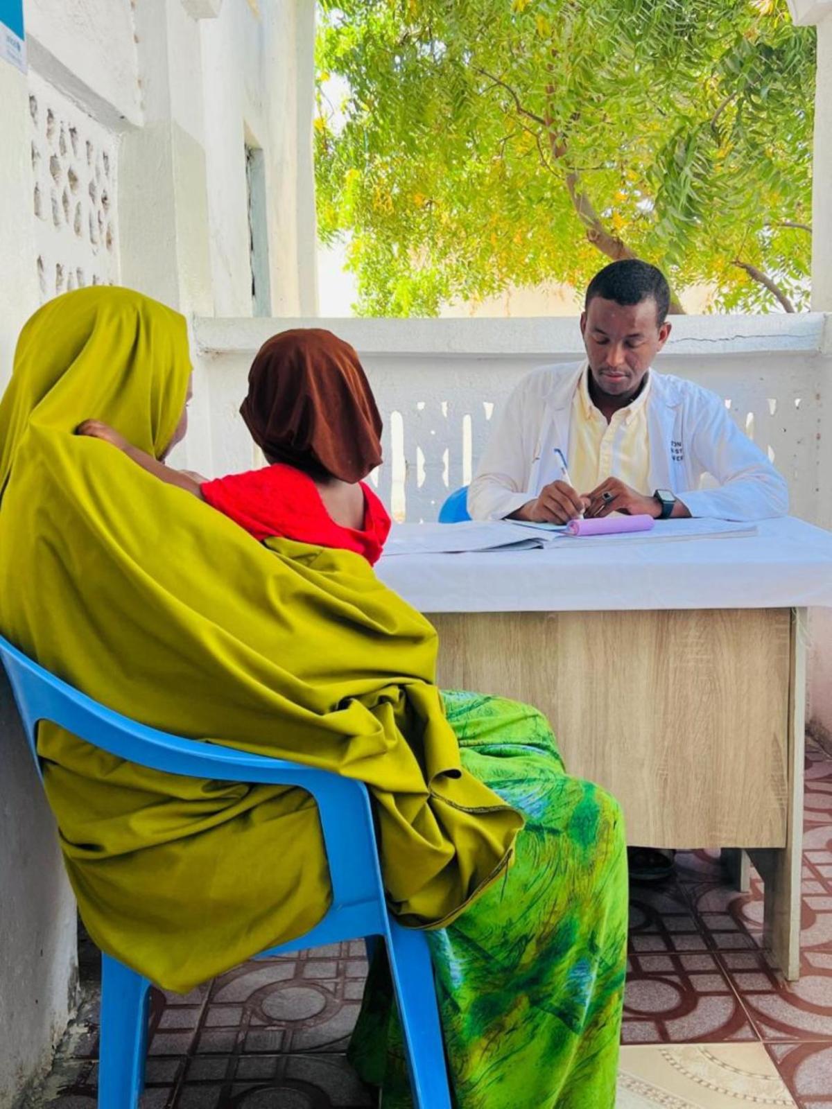 At an Action Against Hunger-supported clinic in Kismayo, a mother discusses vaccination options for her child with a doctor. 