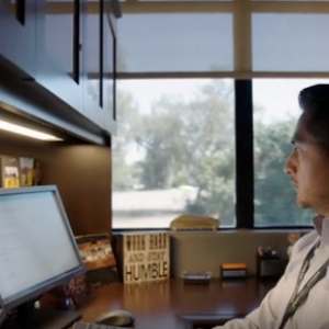 A man sitting at a desk with two monitors