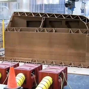 A large 3D printer producing the home in a factory.