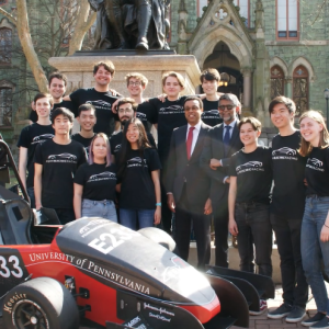 Group of students in front of race car