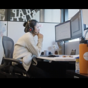 worker in a headset sitting at a desk in front of a map of the US