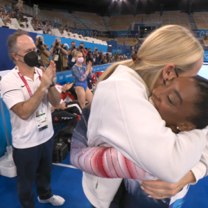 Ceci and Simone hug on the sidelines of a gymnastics competition