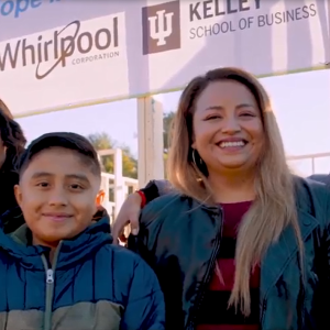 A parent and three kids in front of a new home-build site