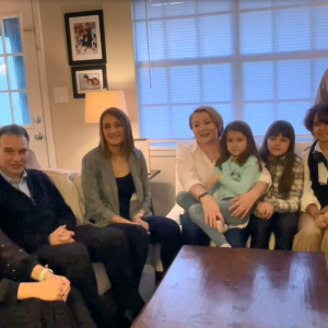 Associates and family sit down in a living room