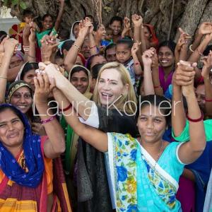 Laura Kohler holding raised hands with women