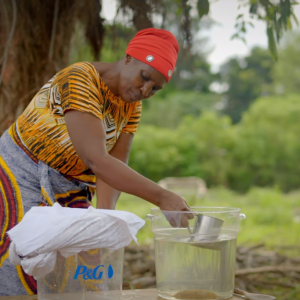 Woman scooping out clean water from a P&G bucket
