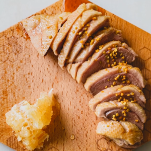 A plated dish of sliced duck and honeycomb