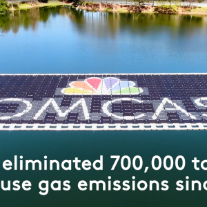 A pond with a raft of solar panels "Comcast" and logo displayed on top.