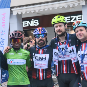 Team of bike racers with arms around each other.