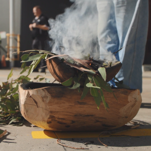 A person standing next to a ceremonial fire