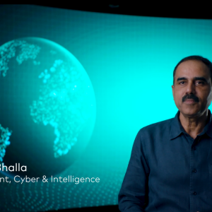 Ajay Bhalia in front of a digital screen of a globe.