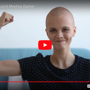 young bald person puts their arm up in a strong sign