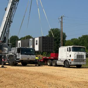 Container being placed on truck by crane