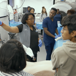 Instructor speaking to students and displaying medical equipment