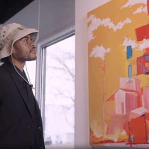 Justin Ellis looking at art hung up on the wall