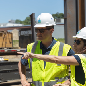 Three people wearing hi-vis vests and hard hards while on site