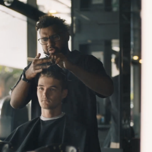 A person getting a haircut in a barber chair.