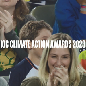 IOC Climate Action Awards 2023 over people in stadium seating clapping.