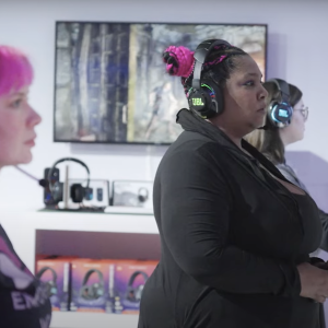 Three women shown playing video games at the JBL Quantum Changemakers Challenge. at the 