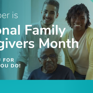 Two people standing behind a third seated. "November is National Family Caregivers Month. Thank you for all that you do."