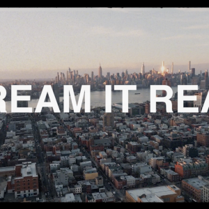 "DREAM IT REAL" over city skyline