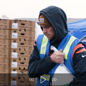 volunteer puts a turkey in a car trunk