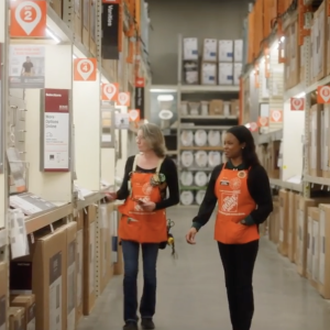 Kierra Blake and an employee walking through aisle in Home Depot store